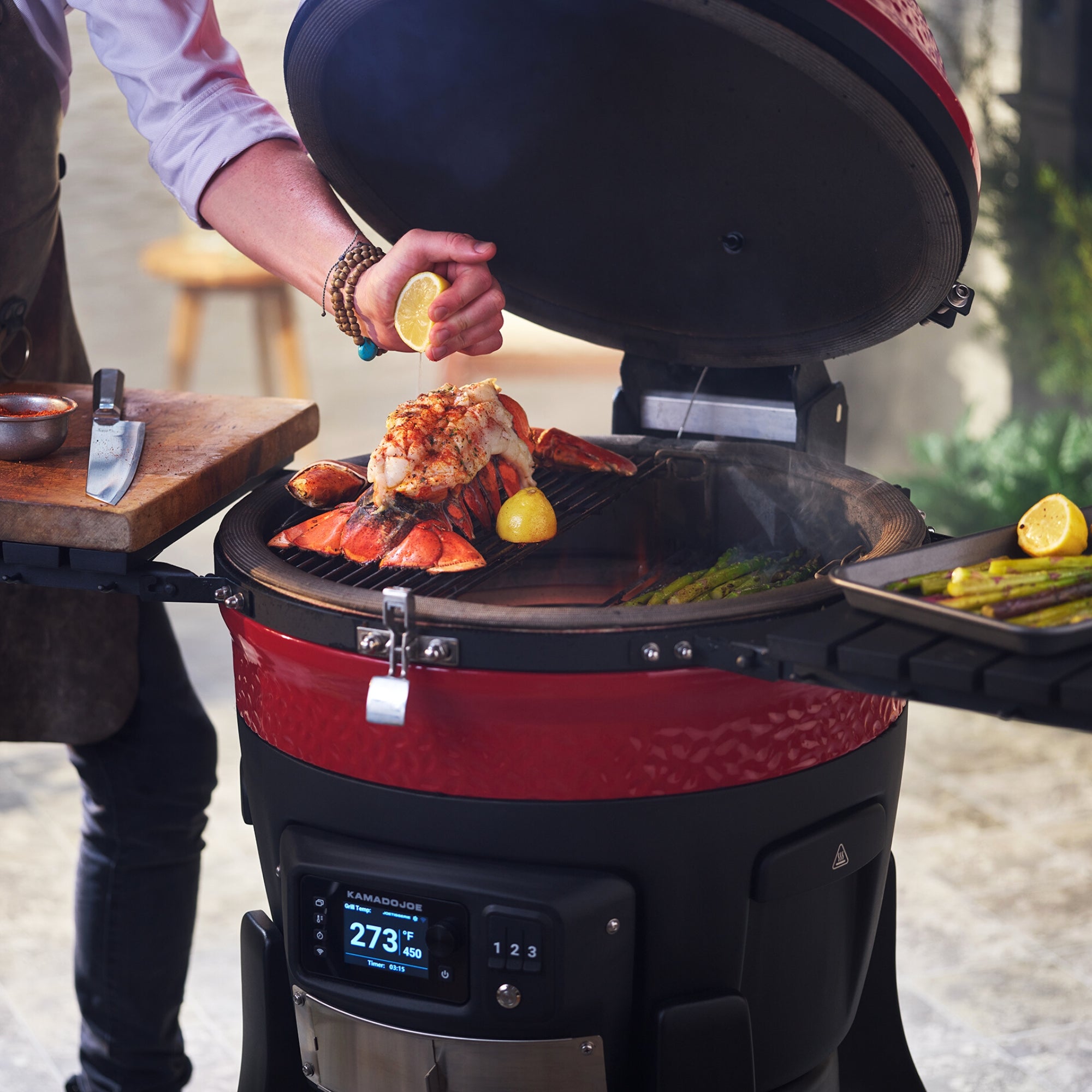 Cuisson d'aliments en plein air sur les grilles du Kamado Joe Konnected Joe, couvercle ouvert